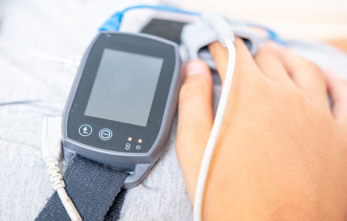 Band around the chest and a hand on the chest. There's also a clip (oxygen monitor) on a fingertip.