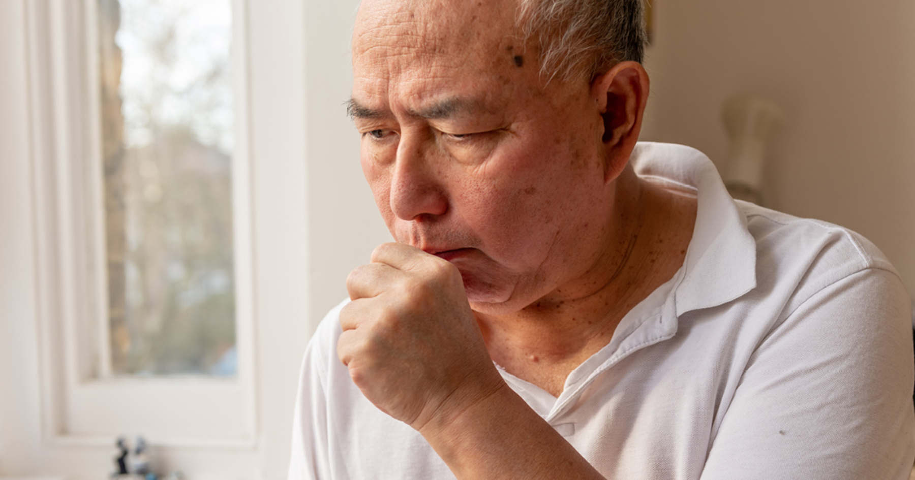 An elderly man coughing