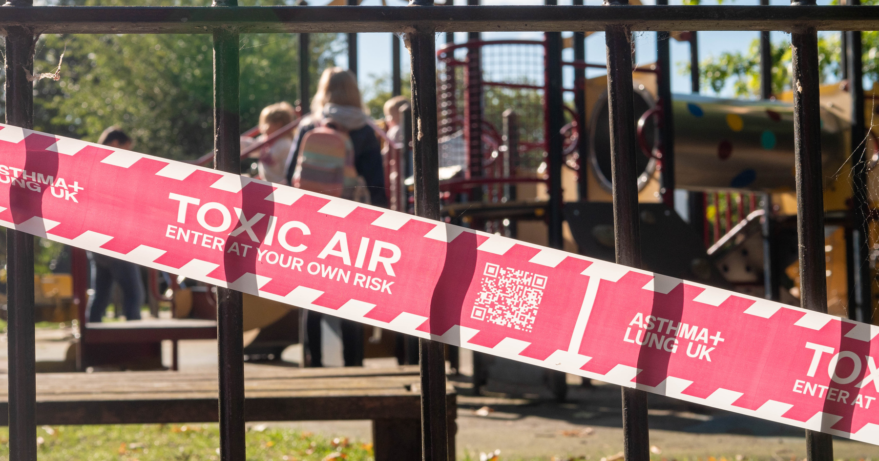 Toxic air hazard tape with playground in background