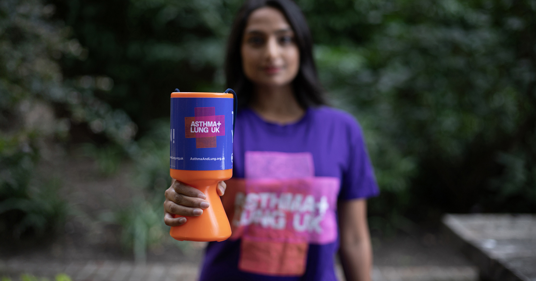 Woman holding collection tin with asthma and lung uk branding