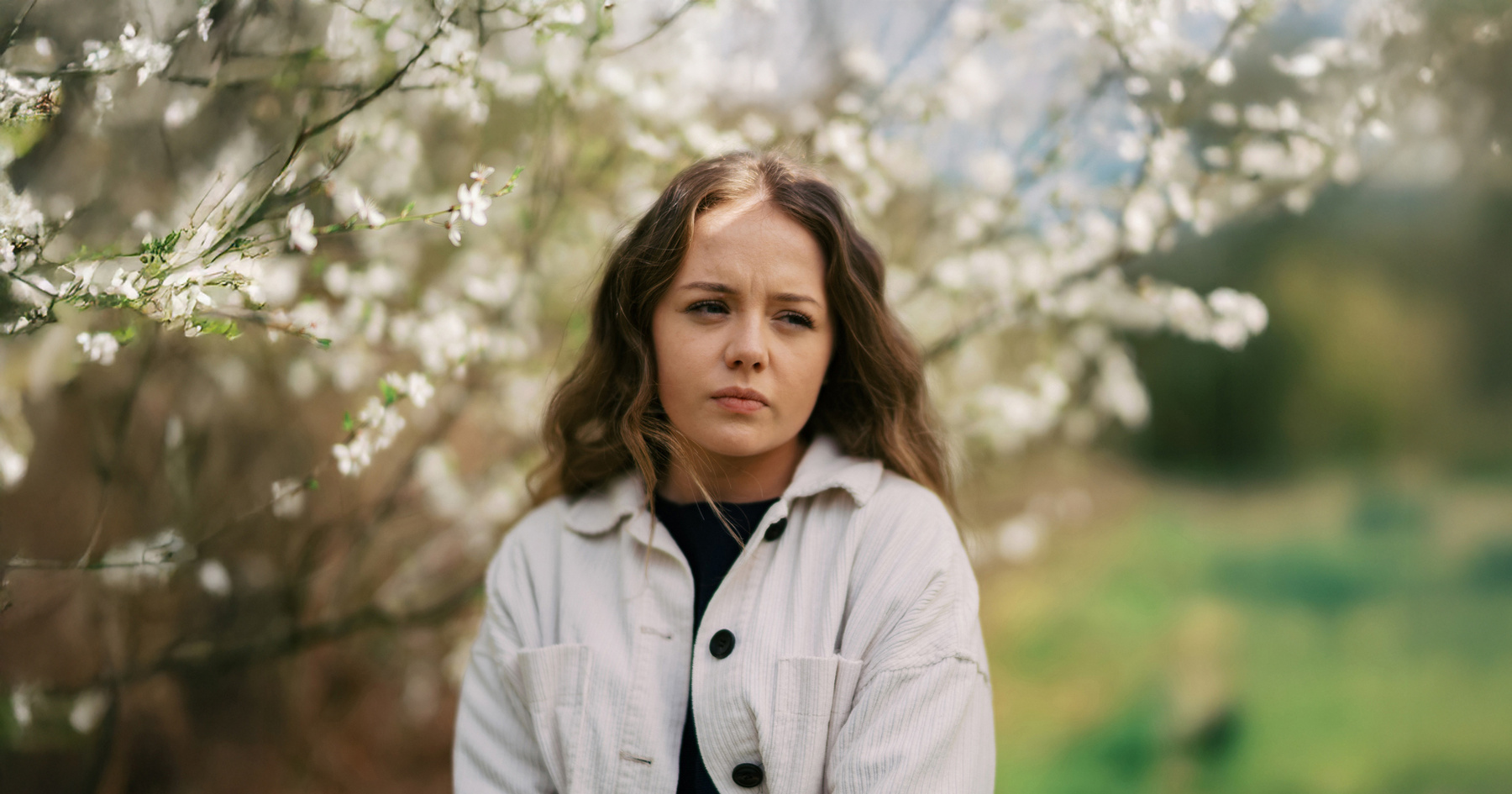 Woman standing under blossoming tree in summer