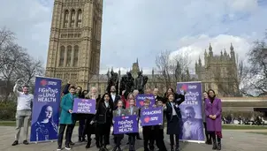 Group of people standing outside the Houses of Parliament campaigning