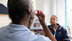 Patient showing technique for using inhaler with a nurse. 