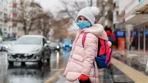 Child wearing a face mask in the street