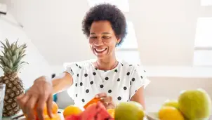 Person choosing from a selection of fruits