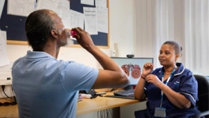 Man using an inhaler with a health professional