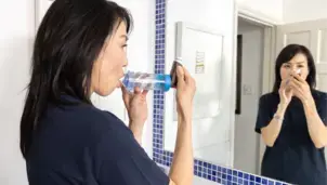 Woman using an inhaler and spacer
