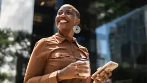 Woman walking with a coffee and phone