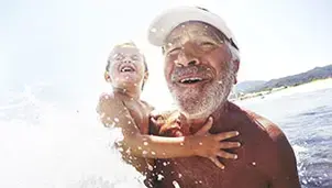 Grandfather and grandson in the sea