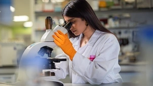 A woman looking through a microscope