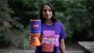 Woman holding collection tin with asthma and lung uk branding