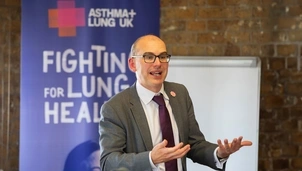 Man speaking in front of a poster that says fighting for lung health