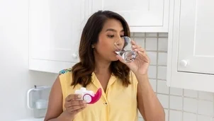 Person drinking water after using their combination inhaler