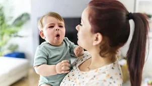 Person holding a coughing baby
