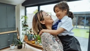 Mum holding their child in school uniform