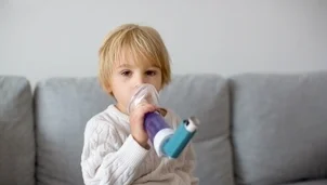 Child using their inhaler with a spacer and face mask