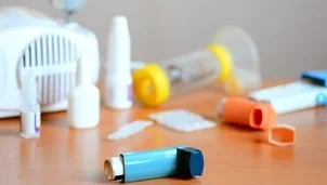 Inhalers and a spacer with a face mask on a table