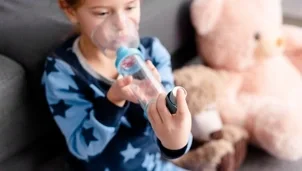 Child using an inhaler and spacer