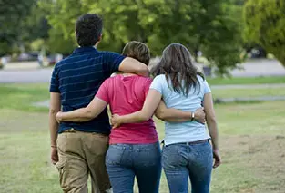 Group of people walking with their arms around each other